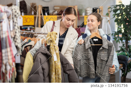 Teen girl with mother choosing something for autumn-winter in clothing store 134191756