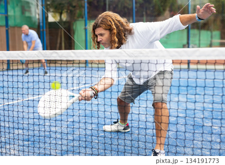 Caucasian man playing paddle tennis on padel court Caucasian man playing paddle tennis on padel court 134191773