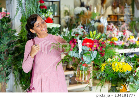 Female customer chooses bouquet of flowers at flower shop Female customer chooses bouquet of flowers at flower shop 134191777
