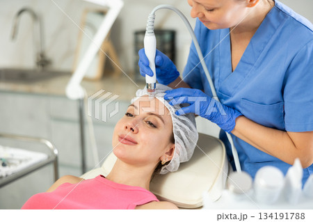 Female dermatologist performing cosmetology procedure for young girl, absorb blackheads and deeply clear skin and deep hydration for facial skin therapy in clinic Female dermatologist performing cosmetology procedure for young girl, absorb blackheads and deeply clear skin and deep hydration for facial skin therapy in clinic 134191788