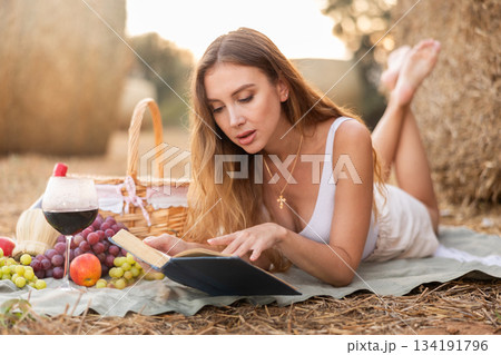 Young woman lying reading book during picnic 134191796