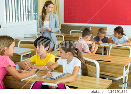 Tweens working in small groups during lesson at school Tweens working in small groups during lesson at school 134191823