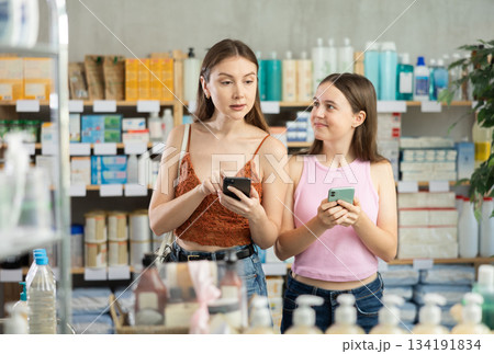 Woman and adolescence girl in pharmacy with phone Woman and adolescence girl in pharmacy with phone 134191834