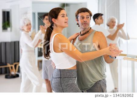 Active sportive men and women enjoying of partner dance in dance studio 134192002