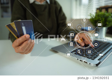 Online payment of hands of women holding smartphone and using credit cards and laptop computers for online shopping. 134192031