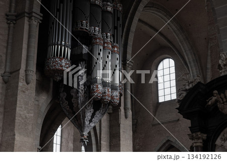 Grand pipe organ in Trier Cathedral features ornate floral carvings and dramatic suspended structure rising above stone arches Grand pipe organ in Trier Cathedral features ornate floral carvings and dramatic suspended structure rising above stone arches 134192126