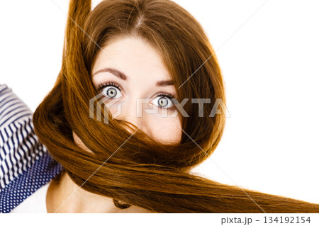 Woman having face covered with her brown hair Woman having face covered with her brown hair 134192154