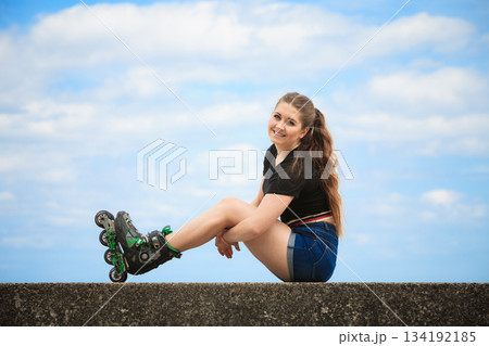 Happy young woman wearing roller skates 134192185
