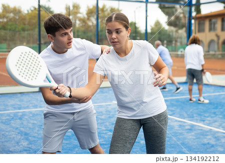 Paddle tennis instructor giving lessons to girl 134192212