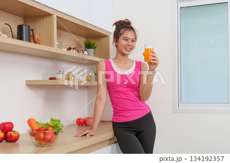 Refreshing Drink. Woman enjoying healthy juice in modern kitchen. Refreshing Drink. Woman enjoying healthy juice in modern kitchen. 134192357
