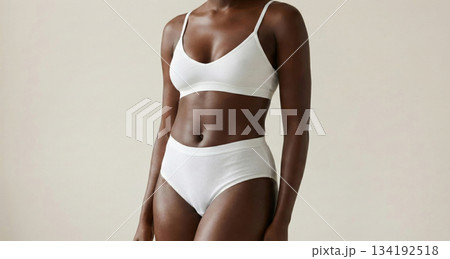 Cropped shot of a fit young woman with beautiful glossy tanned dark skin wearing a comfortable white ribbed lingerie set.  134192518