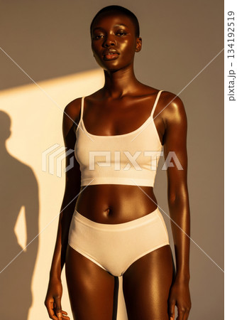 Cropped shot of a fit young woman with beautiful glossy tanned dark skin wearing a comfortable white ribbed lingerie set.  134192519