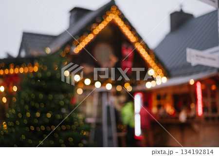 Abstract, blurry background of a Christmas market with bokeh lights on the roofline and tree, festive winter shopping 134192814
