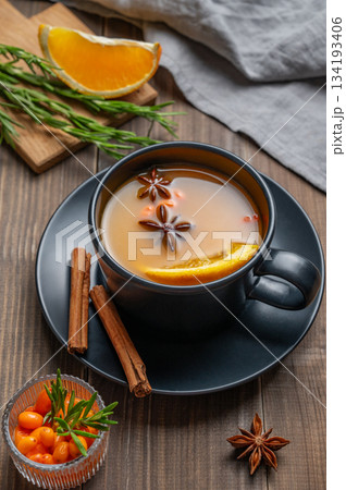 Sea buckthorn herbal tea in a black cup on a wooden background with spices Sea buckthorn herbal tea in a black cup on a wooden background with spices 134193406