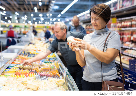 Elderly woman choose cheese in supermarket 134194494