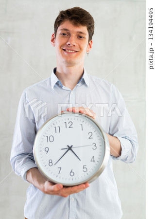 Young guy posing with clock in studio 134194495