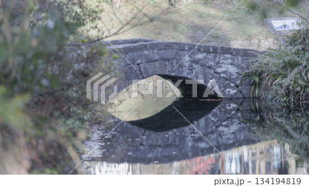 秋の終わり、明神池名水公園の眼鏡橋、水面に映る風景 134194819