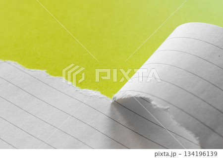 Ripped white paper with lined texture on a bright yellow background. The torn edge creates a contrast between the two colors. Ripped white paper with lined texture on a bright yellow background. The torn edge creates a contrast between the two colors. 134196139