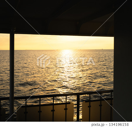 日没間近かの夕暮れの海をフェリーから一人眺めているイメージ 日没間近かの夕暮れの海をフェリーから一人眺めているイメージ 134196158