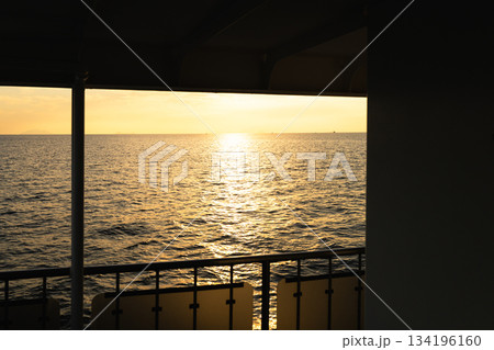 日没間近かの夕暮れの海をフェリーから一人眺めているイメージ 日没間近かの夕暮れの海をフェリーから一人眺めているイメージ 134196160
