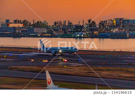 【東京都】夕焼け空に覆われた羽田空港の風景　駐機中の旅客機 134196619