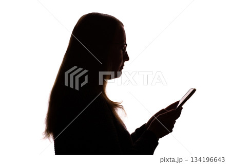 Silhouette of young woman using smartphone on white background Silhouette of young woman using smartphone on white background 134196643