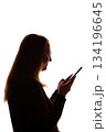 Silhouette of young woman using smartphone on white background 134196645