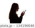 Silhouette of young woman using smartphone on white background 134196646