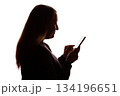 Silhouette of young woman using smartphone on white background 134196651