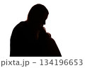 Silhouette of young woman sitting with loose hair, depressed 134196653
