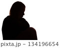 Silhouette of young woman sitting with loose hair, depressed 134196654