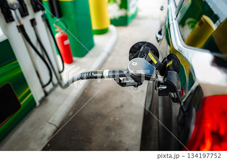 Diesel fuel nozzle filling car tank at gas station 134197752