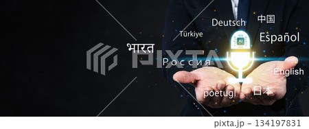 Businessman presenting artificial intelligence language translation above his open hand. Glowing AI logo inside a virtual microphone surrounded by several languages 134197831