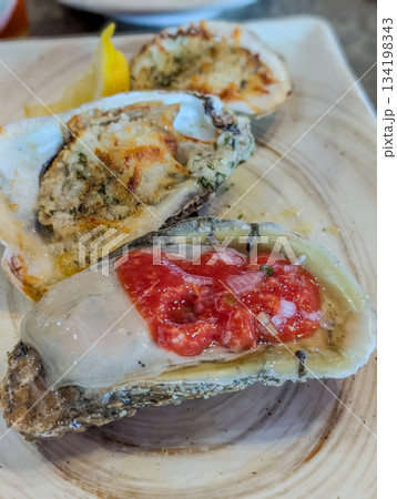 Closeup of fresh oysters on ice with lemon wedges Closeup of fresh oysters on ice with lemon wedges 134198343