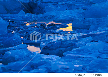水面に映る夕日と氷塊 134198808