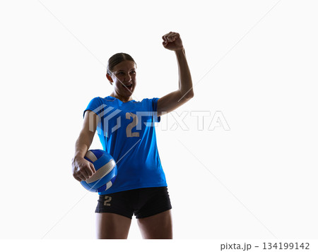Volleyball player raising fist with ball for digital gamification and app rewards. 134199142