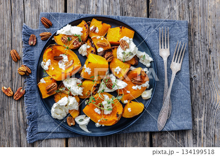 baked butternut squash with cheese, thyme, pecan 134199518