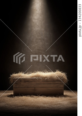 Wooden manger with straw under soft spot light. Empty wooden manger with straw receiving warm light, symbolizing birth and new beginnings 134200833