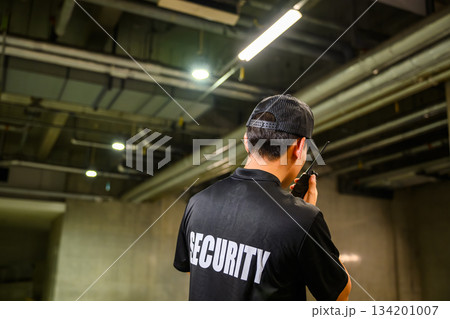 駐車場で見回りをする警備員の後ろ姿 134201007