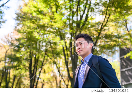 緑を背景に未来を見つめる男性 134201022