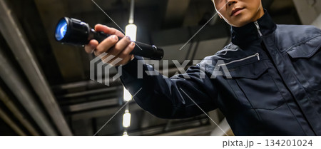 警備員が暗闇で懐中電灯 134201024