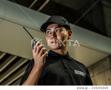 警備員がトランシーバーを持つ 警備員がトランシーバーを持つ 134201026