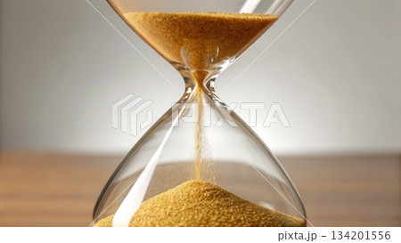 Hourglass filled with golden sand flowing upward, symbolizing 134201556