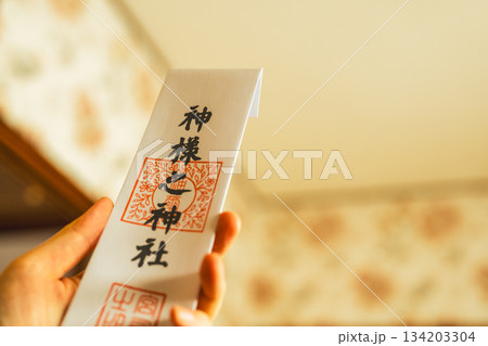 手で持つ神札と温かい光 134203304