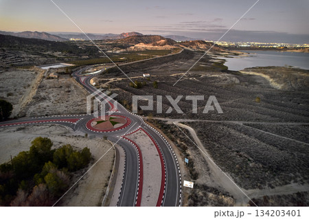Aerial view of curved road and modern roundabout Aerial view of curved road and modern roundabout 134203401