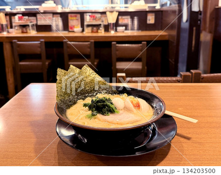 Delicious bowl of tonkotsu ramen with pork, egg, and nori on a wooden table 134203500