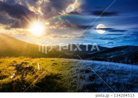 beautiful countryside. day and night time change concept. scenic view of grassy field and rolling hills. wonderful summertime landscape in mountains with sun and moon. duality and transition template beautiful countryside. day and night time change concept. scenic view of grassy field and rolling hills. wonderful summertime landscape in mountains with sun and moon. duality and transition template 134204513