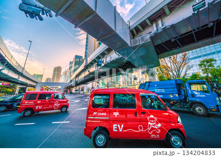 日本の東京都市景観師走の慌ただしさ…汐留のビジネス街を次々と郵便配達車が通りすぎる。右奥は電通本社 日本の東京都市景観師走の慌ただしさ…汐留のビジネス街を次々と郵便配達車が通りすぎる。右奥は電通本社 134204833