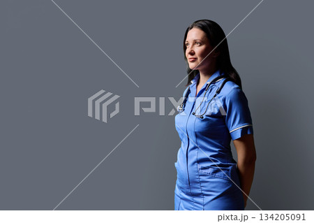 Profile portrait of middle-aged woman doctor, nurse on grey studio background 134205091