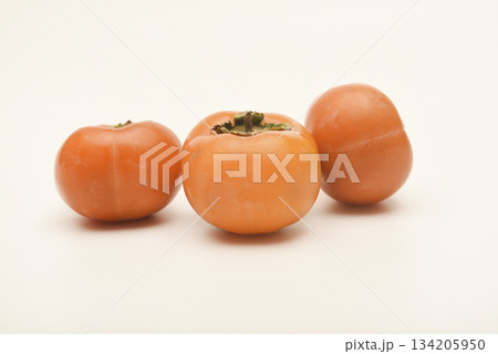 Orange persimmon fruits. Ripe persimmon on a white background. Juicy fruits. Orange persimmon fruits. Ripe persimmon on a white background. Juicy fruits. 134205950